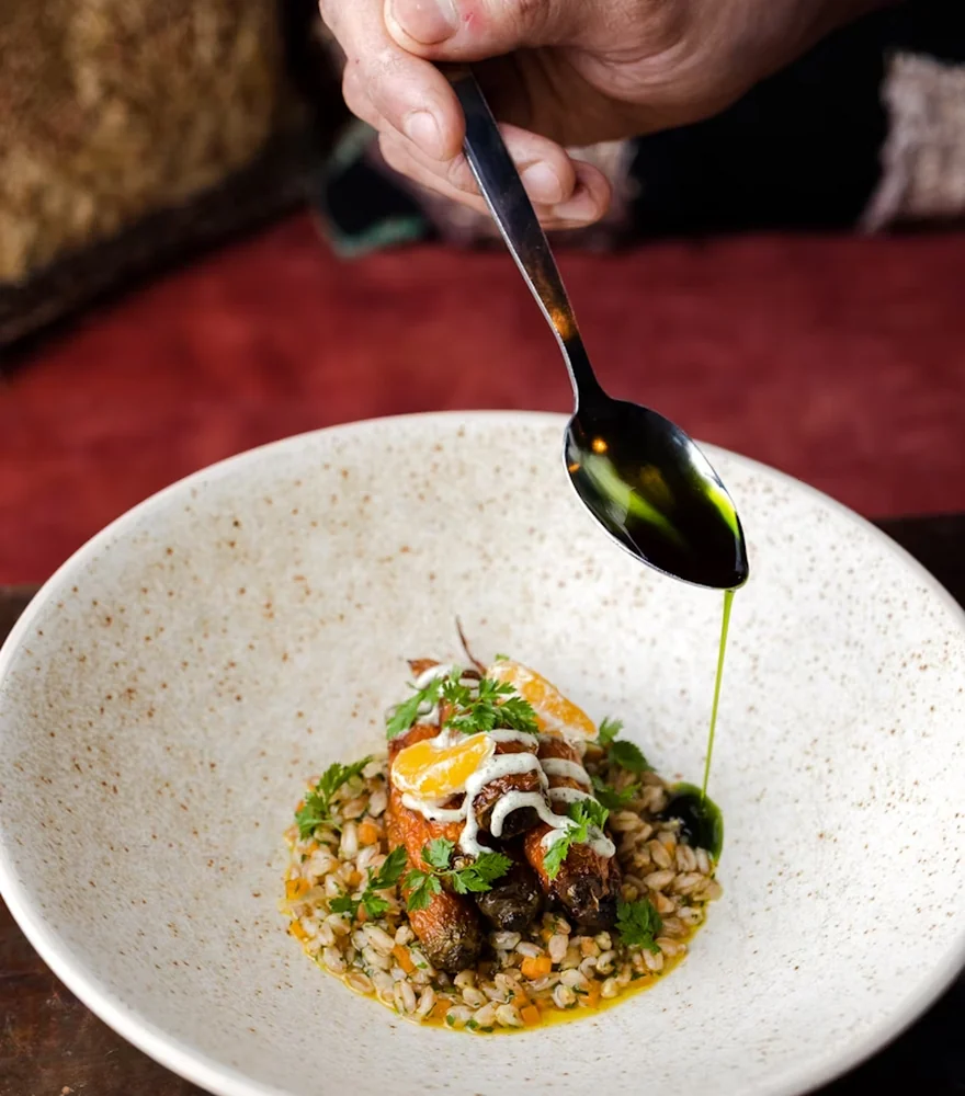 Chef plating a fine dining dish in a restaurant kitchen