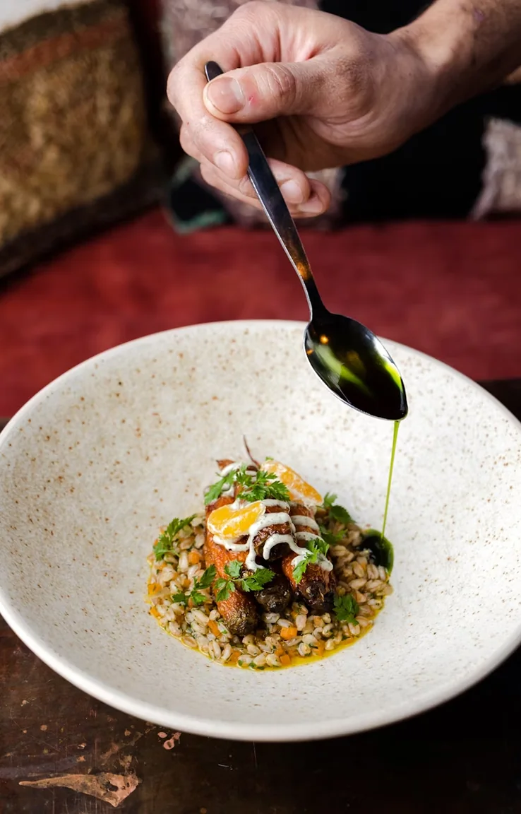 Chef plating a fine dining dish in a restaurant kitchen