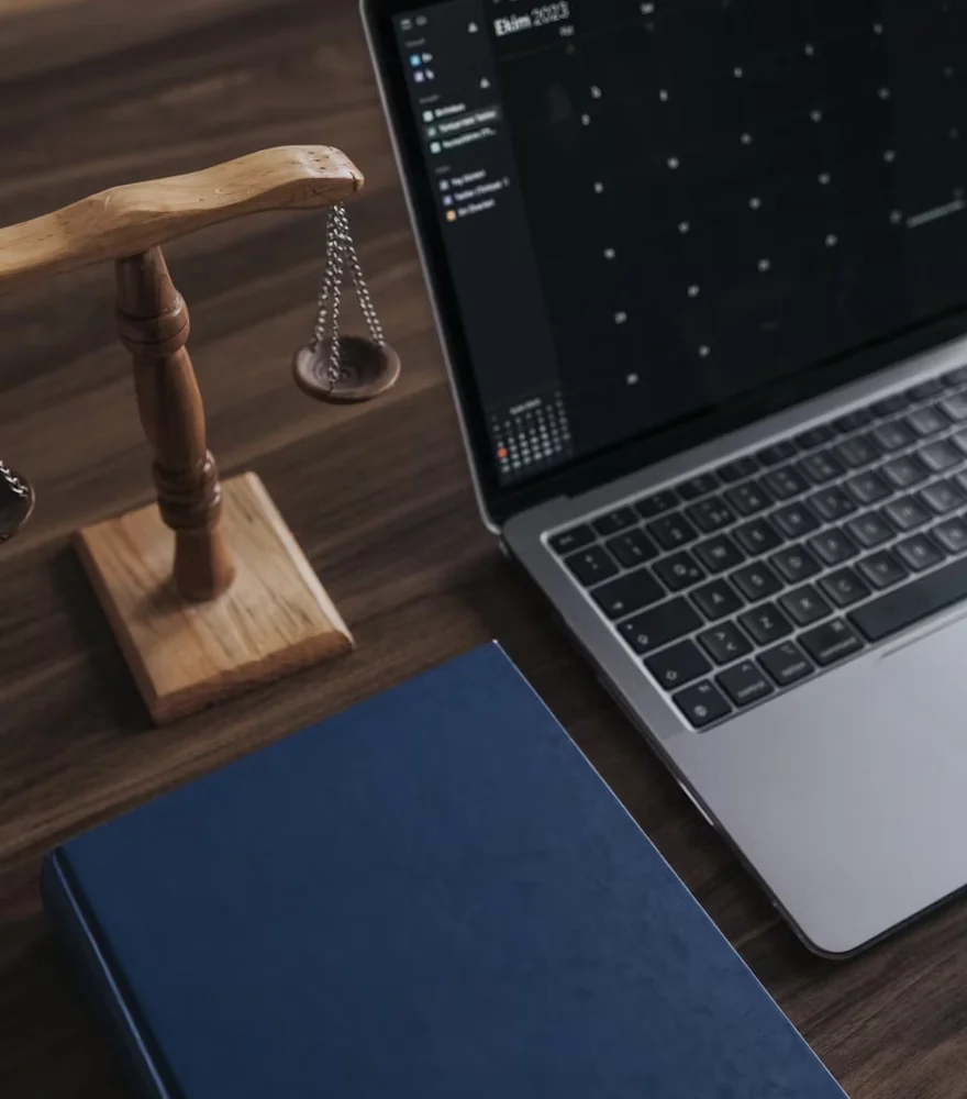Scales of justice beside an open laptop on a professional services desk