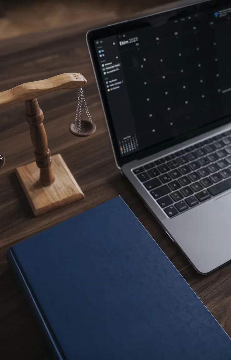 Scales of justice beside an open laptop on a professional services desk